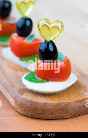 Einfachen Snack Canape mit Tomaten, Mozzarella und Basilikum Nahaufnahme auf hölzernen Hintergrund Stockfoto