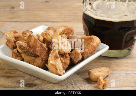 traditionelle englische Midland snack von gesalzenem Schweinefleisch Grieben mit einem Pint Bier Stockfoto
