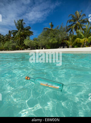 Eine Flaschenpost angeschwemmt an einem tropischen Strand. Stockfoto