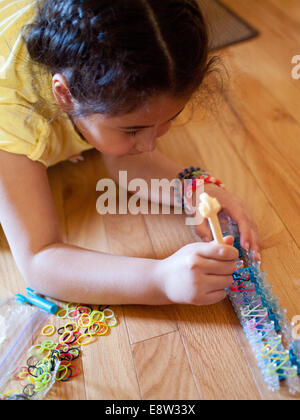 Ein Niedliche Kleine Madchen Webt Eine Armband Mit Einem Regenbogen Webstuhl Ein Beliebtes Spielzeug Verwendet Um Die Gummibander Zu Armbandern Und Charms Zu Verweben Stockfotografie Alamy