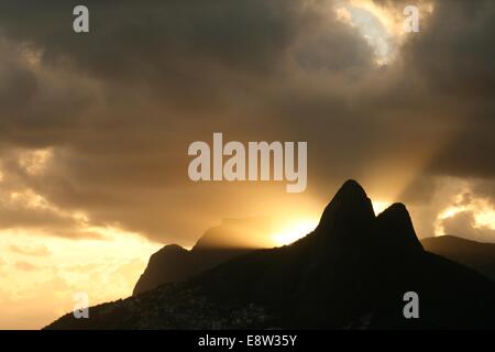 Pedra da Gávea (Gavea Rock) und Morro Dois Irmãos (zwei Brüder Hill) bei Sonnenuntergang, von Arpoador Beach gesehen. Rio De Janeiro, Brazi Stockfoto