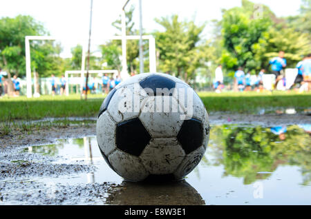 schmutzige Fußball auf schmutzigen Boden für das Spiel in der Regenzeit Stockfoto