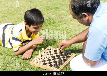 1 indischer Mann spielt Schach mit Kind Stockfoto