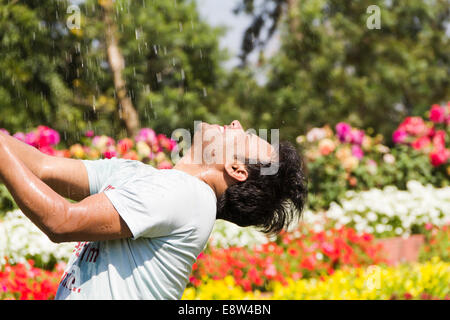 1 indischer Mann sprühen Wasser und Baden Stockfoto