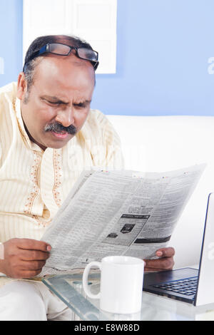 1 indischer Mann lesen Zeitung zu Hause Stockfoto