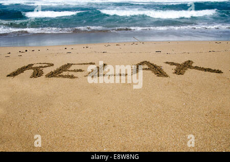 Das Wort Entspannung in den Sand am Strand geschrieben Stockfoto