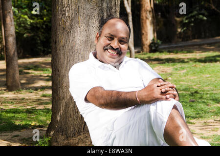 1 indischer Mann sitzen im Park Stockfoto
