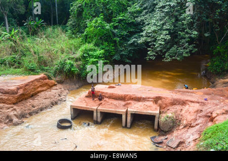 Schlechte Infrastruktur in Nigeria, Feldwege, Überschwemmungen und Kinder spielen mit unfertigen Brücken Stockfoto