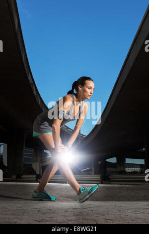 Frau, dehnen vor dem Training auf Stadtstraße Stockfoto