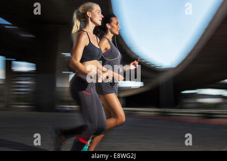 Frauen, die zusammen durch Straßen der Stadt laufen Stockfoto