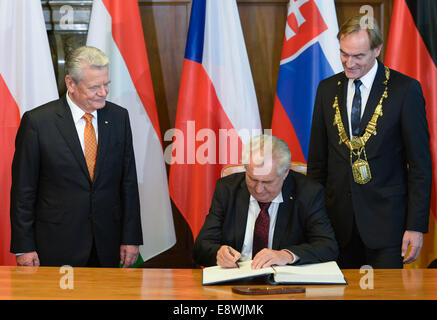 Leipzig, Deutschland. 9. Oktober 2014. Deutscher Präsident Joachim Gauck (L) beobachtet, wie Czech President Milos Zeman (C) das Goldene Buch der Stadt Leipzig neben der Leipziger Oberbürgermeister Burkhard Jung (SPD, R) in Leipzig, Deutschland, 9. Oktober 2014 unterzeichnet. Die Preisverleihung fand anlässlich des 25-jährigen Jubiläums der "Friedlichen Revolution" in Leipzig statt. Foto: Peter Endig/Dpa/Alamy Live News Stockfoto