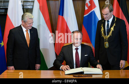 Leipzig, Deutschland. 9. Oktober 2014. Deutscher Präsident Joachim Gauck (L) beobachtet, wie Slovak President Andrej Kiska (C) das Goldene Buch der Stadt Leipzig neben der Leipziger Oberbürgermeister Burkhard Jung (SPD, R) in Leipzig, Deutschland, 9. Oktober 2014 unterzeichnet. Die Preisverleihung fand anlässlich des 25-jährigen Jubiläums der "Friedlichen Revolution" in Leipzig statt. Foto: Peter Endig/ZB/Dpa/Alamy Live News Stockfoto