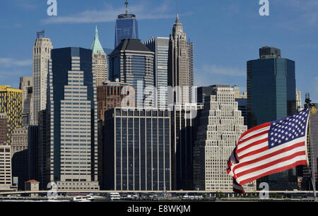 Eine amerikanische Flagge winken vor der Skyline von Midtown Manhattan, wie von der anderen Seite des East River in New York City, 15. September 2014 gesehen. In der Mitte ragt oben auf dem neuen One World Trade Center über Bürogebäude. Foto: Soeren Stache/Dpa - NO-Draht-Dienst- Stockfoto