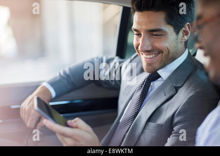 Geschäftsleute suchen am Handy im Auto Stockfoto