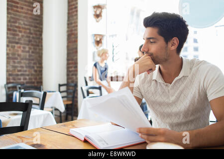 Geschäftsmann, Blick auf Dokumente im café Stockfoto