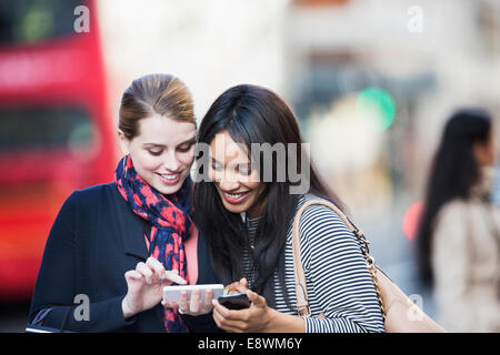 Frauen, die Nutzung von Mobiltelefonen auf Stadtstraße Stockfoto