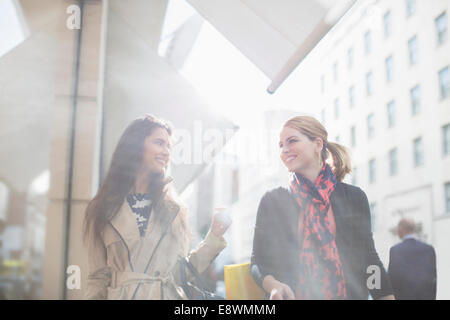 Frauen, die zu Fuß hinunter Stadtstraße zusammen Stockfoto