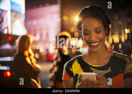 Frau mit Handy auf Stadtstraße in der Nacht Stockfoto