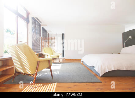 Sessel, Teppich und Bett im modernen Schlafzimmer Stockfoto