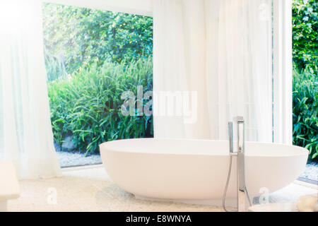 Badewanne, Vorhänge und Fenster im modernen Badezimmer Stockfoto