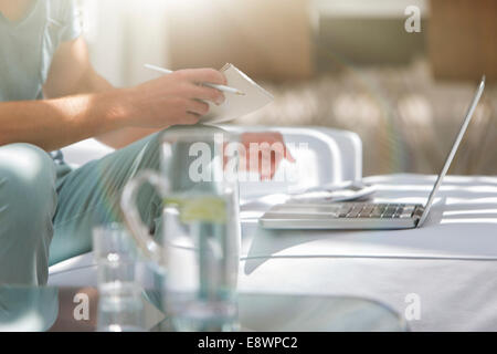 Mann, die Zahlung von Rechnungen auf Laptop Couchtisch Stockfoto