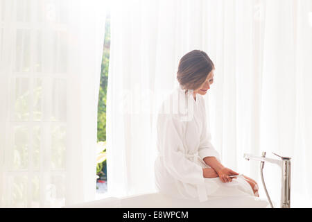 Frau rennt Badewanne im modernen Badezimmer Stockfoto