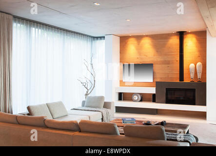 Sofas, Gardinen und Kamin im modernen Wohnzimmer Stockfoto