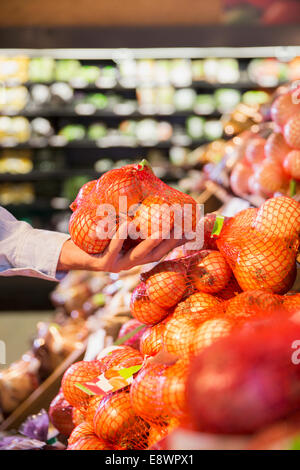 Nahaufnahme von Mann, hält Beutel mit Zwiebeln in Lebensmittelgeschäft Stockfoto