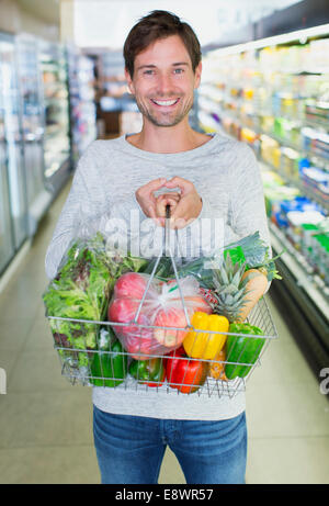 Mann mit vollen Einkaufswagen im Supermarkt Stockfoto