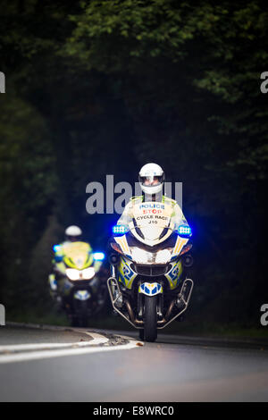 Polizei-Motorradfahrer-Geschwindigkeit mit Blaulicht sicherzustellen, dass die Straße vor Fahrern bei der Tour of Britain 2014 Radrennen klar ist. Stockfoto