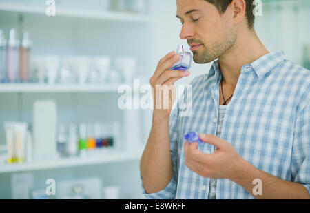 Mann riechendes Parfüm in Drogerie Stockfoto