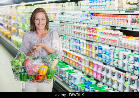 Frau mit vollen Einkaufswagen im Supermarkt Stockfoto