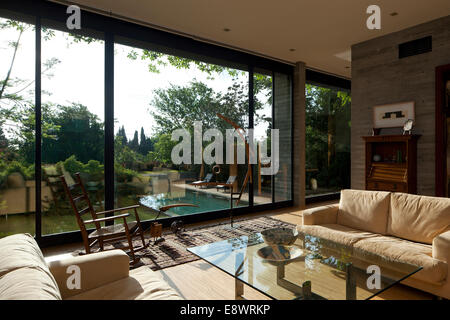 Cremefarbene Sofas und Glas gekrönt Couchtisch mit deckenhohe Fenster im Wohnzimmer von Gotesman House, Israel, Naher Osten. Stockfoto