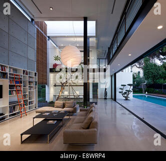 Doppelte Höhe Wohnzimmer mit Bücherregal und große Pendelleuchte Dahan Haus, Israel, Nahost. Stockfoto