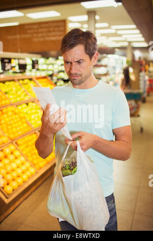 Verwirrten Mann liest Eingang in Lebensmittelgeschäft Stockfoto