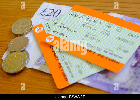 UK-Bahntickets und Geld auf einer Tischplatte fotografiert. Stockfoto