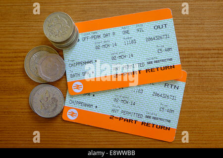 UK-Bahntickets und Geld auf einer Tischplatte fotografiert. Stockfoto