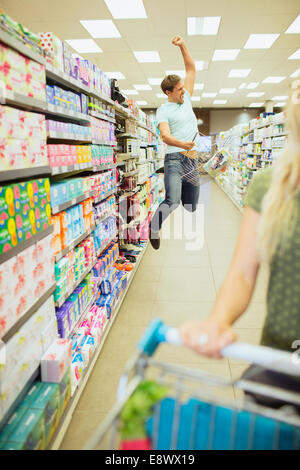 Mann, springen vor Freude im Supermarkt Stockfoto