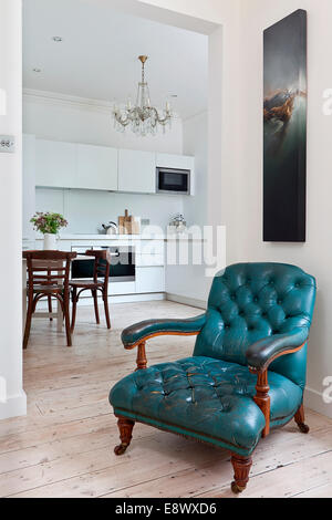 Blauer Sessel im Wohnzimmer mit Blick auf moderne Küche, Hove Stockfoto