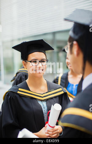 Student in Mütze und Mantel mit Freunden zu reden Stockfoto