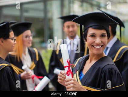 Student in Mütze und Mantel lächelnd mit Hochschulen Stockfoto