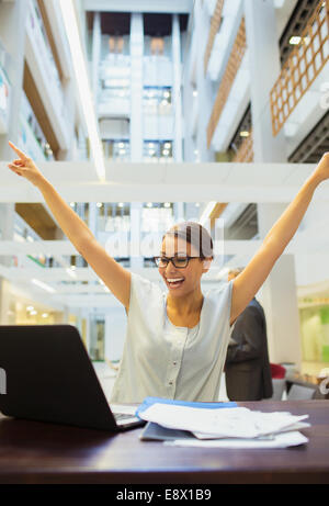 Geschäftsfrau begeistert bei der Arbeit im Bürogebäude Stockfoto