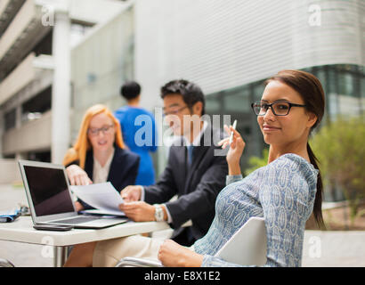 Geschäftsleute im Gespräch am Tisch vor Bürogebäude Stockfoto