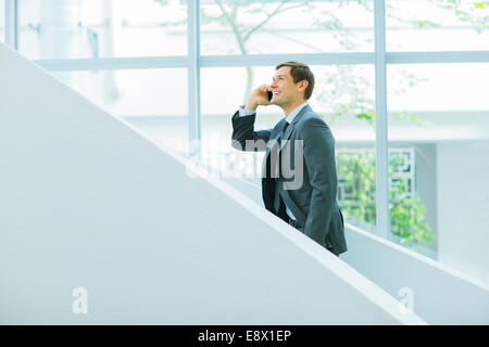 Geschäftsmann, reden über Handy auf Treppe Bürogebäude Stockfoto
