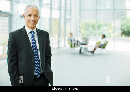 Geschäftsmann lächelnd in Bürogebäude Stockfoto