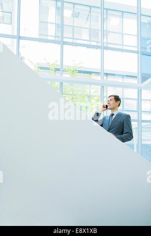 Geschäftsmann, reden über Handy auf Büro-Treppe Stockfoto