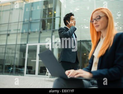 Geschäftsleute, die außerhalb von Bürogebäude Stockfoto