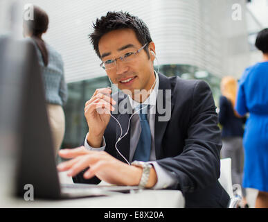 Geschäftsmann am Tisch reden über Kopfhörer Stockfoto