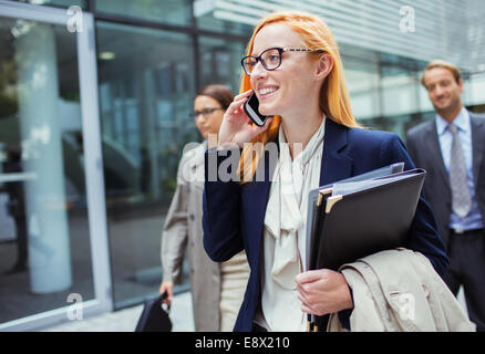 Geschäftsfrau, reden über Handy außerhalb Bürogebäude Stockfoto