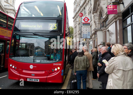 Passagiere, die an einer Bushaltestelle gegenüber der St. Paul's Cathedral warten, um an Bord eines roten Doppeldeckerbusses der Linie 23 zum Ziel Westbourne Park KATHY DEWITT zu gehen Stockfoto